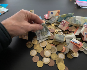 Cash income controls image of hand touching cash notes and coins