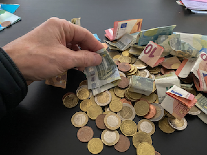 Cash income controls image of hand touching cash notes and coins